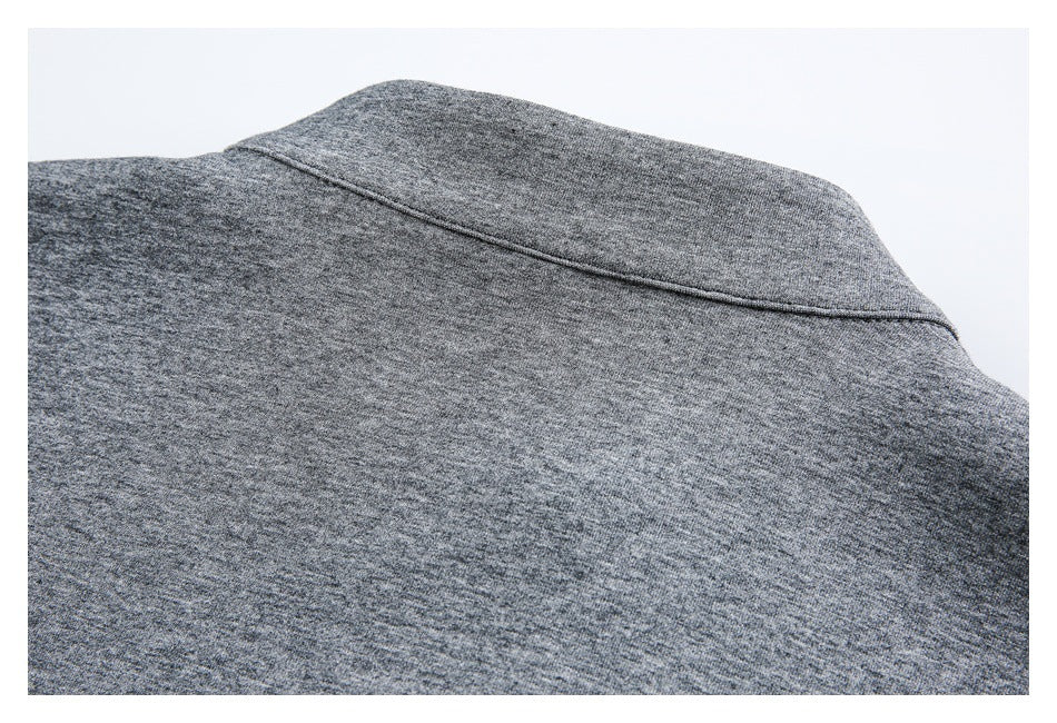 Close-up of the back neckline and seam on a gray heathered garment.