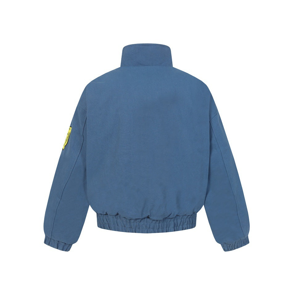 Back view of blue stand-collar bomber jacket with elastic hem and cuffs and a yellow shield patch on the sleeve