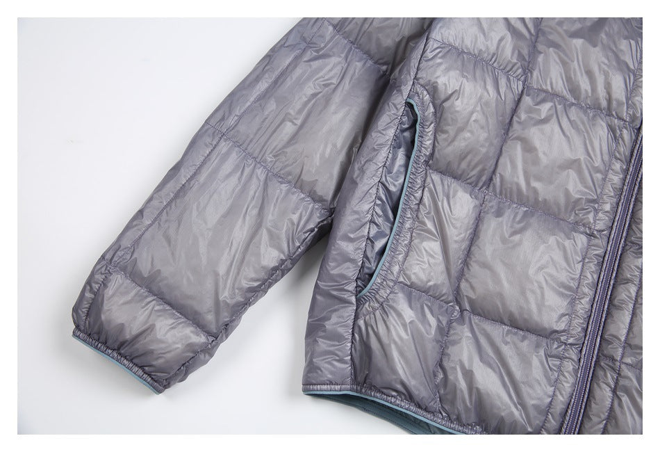 Close-up of a gray quilted jacket sleeve, front pocket opening, and zipper edge with pale blue trim.