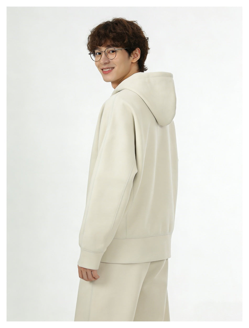 Model in a cream hooded sweatshirt and matching pants, shown from a rear three-quarter angle.