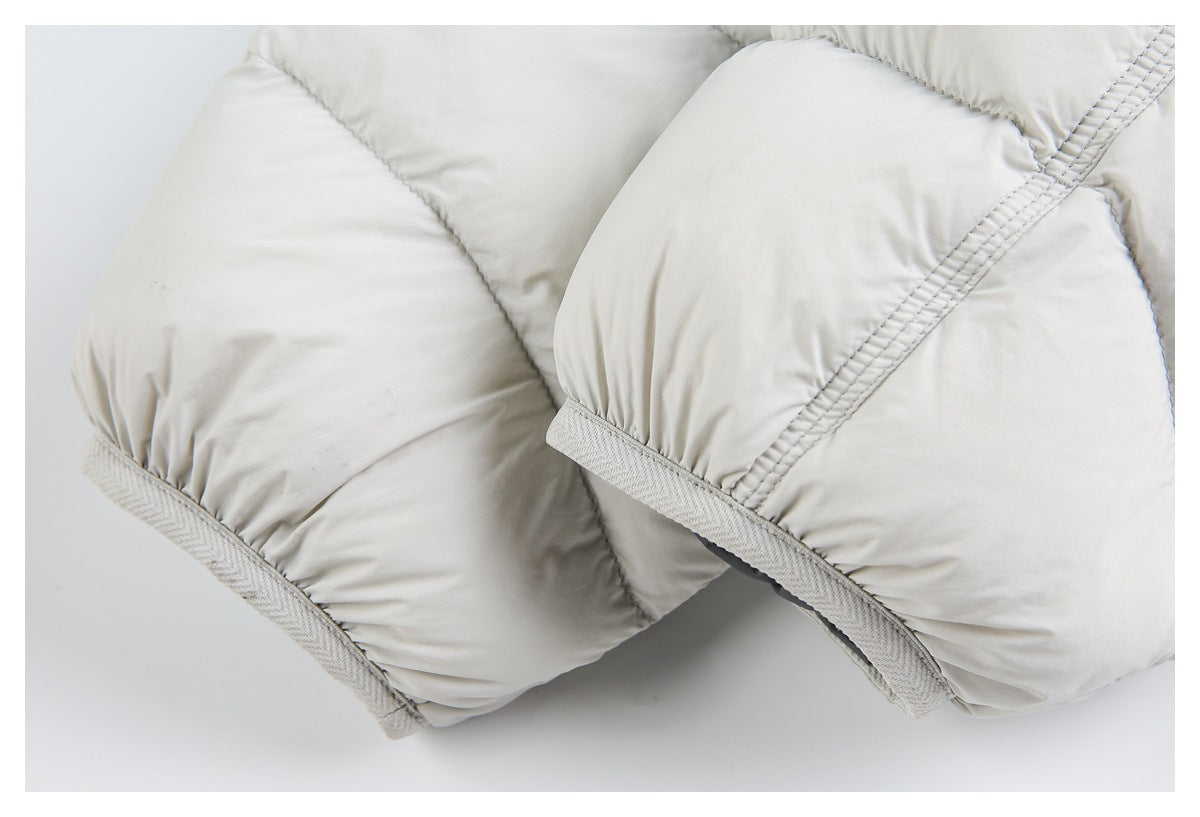 Close-up of ivory quilted sections with light-gray bound edges and parallel stitching.