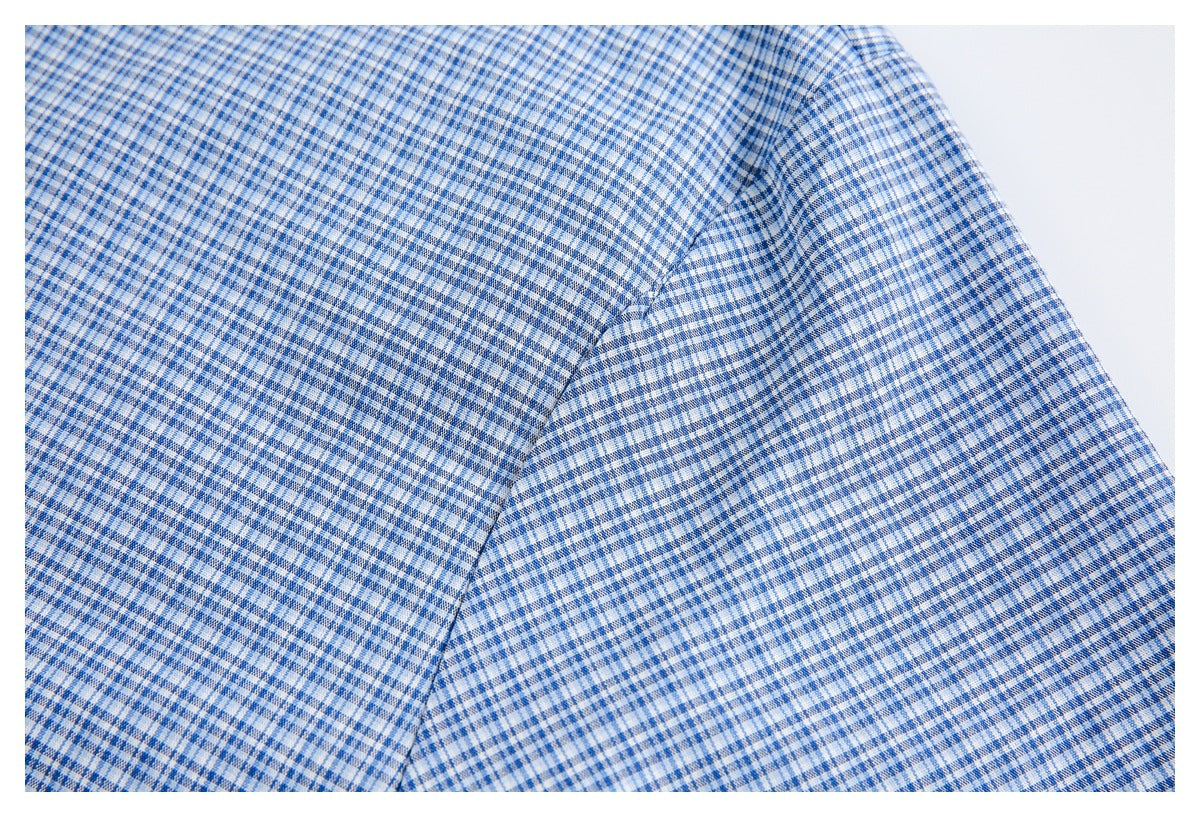 Close-up of the checked shirt's shoulder and short sleeve seam.