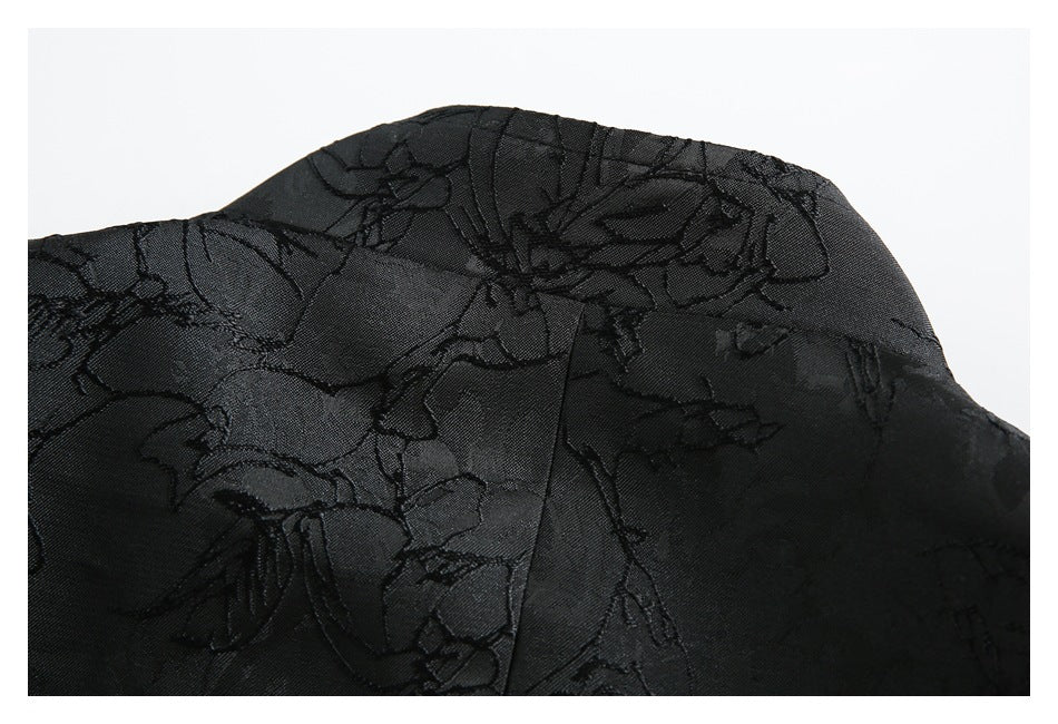 Close-up of the black floral-patterned garment's shoulder seam and stitching.