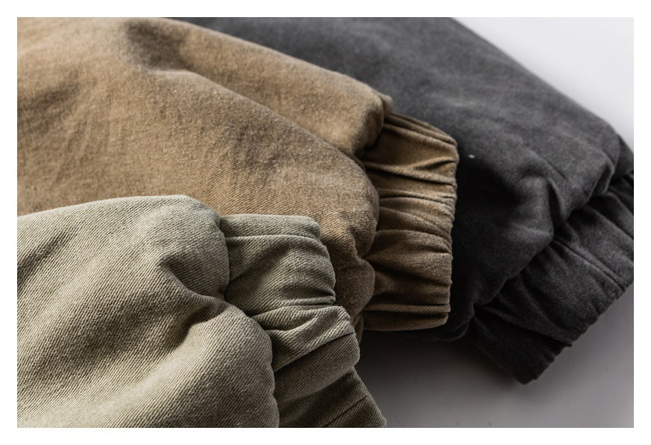 Close-up of gathered cuffs on garments in beige, olive, brown, and charcoal colorways.