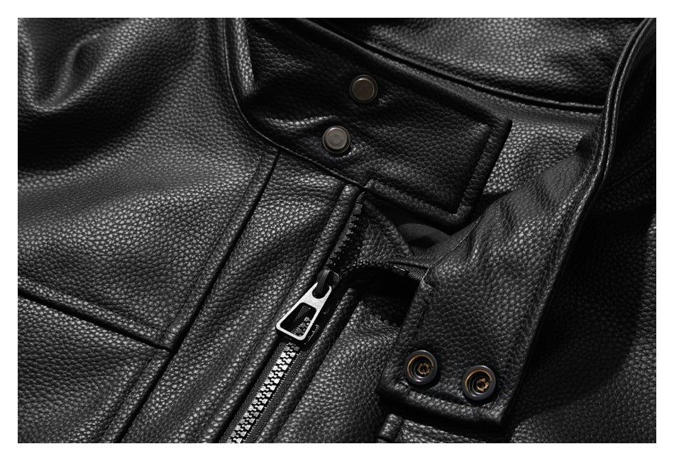 Close-up of the black jacket's front zipper and overlapping snap-fastened tabs.