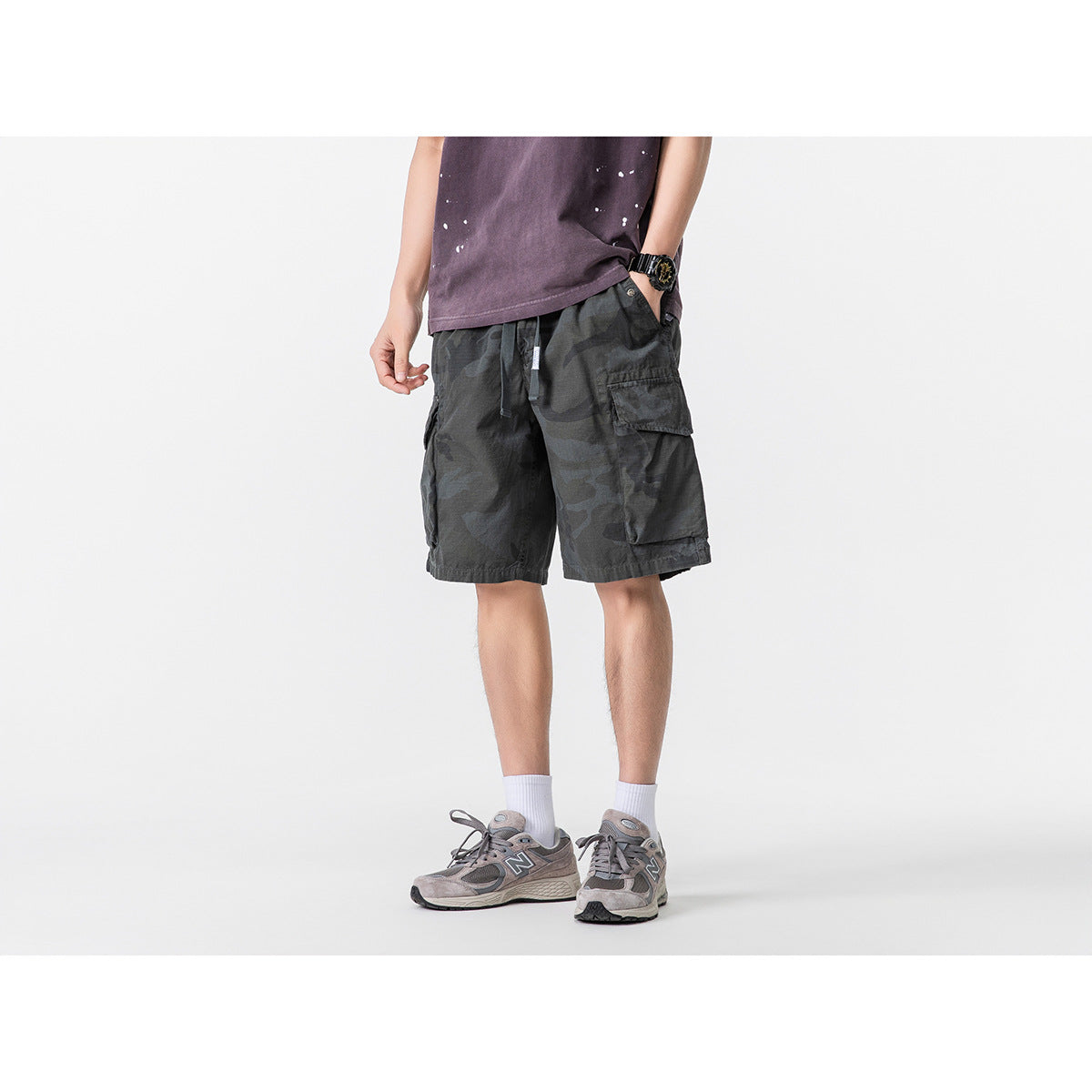 Front view of a model wearing charcoal camouflage cargo shorts with a drawstring waist and side pockets.