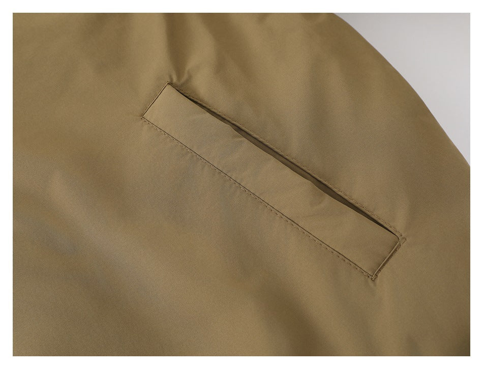 Close-up of a slanted welt pocket on the khaki jacket.