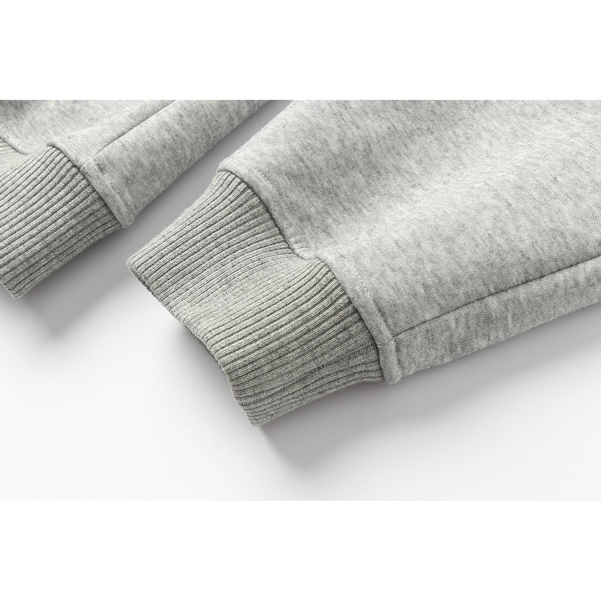 Close-up of the ribbed cuff on a light gray jacket sleeve.