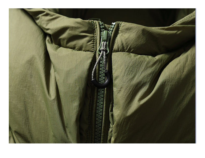 Close-up of an olive jacket's front zipper, corded pull and surrounding fabric.