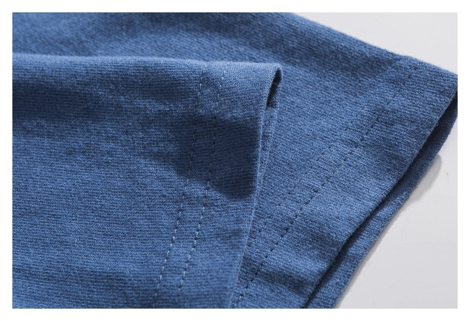 Close-up of the blue T-shirt sleeve and stitched cuff hem.