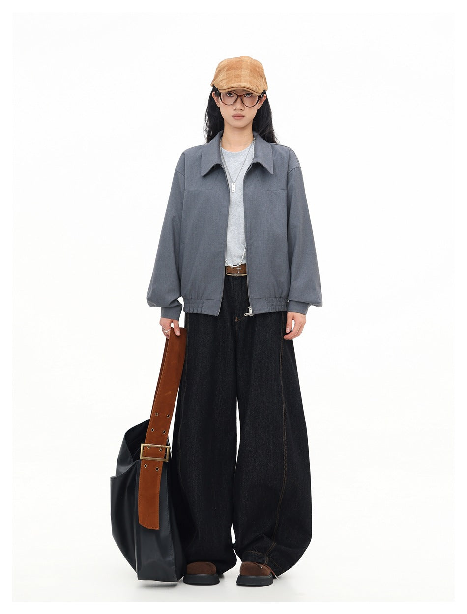 Full-length front view of a model wearing a gray collared jacket with dark wide-leg jeans.