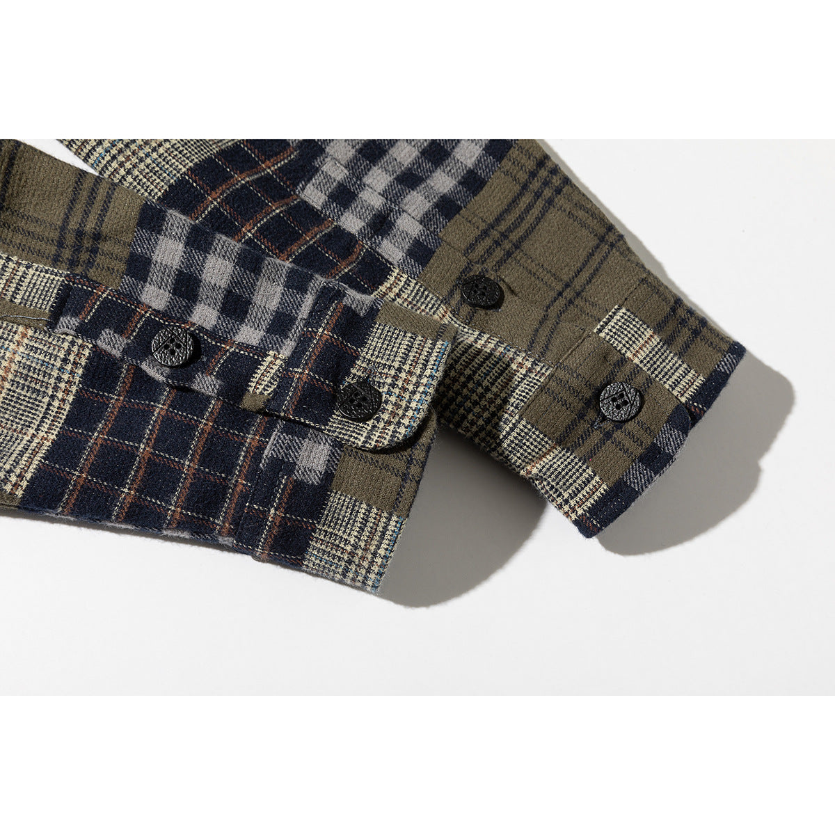 Close-up of the plaid shirt's buttoned cuffs in navy, gray, cream, and olive checks.