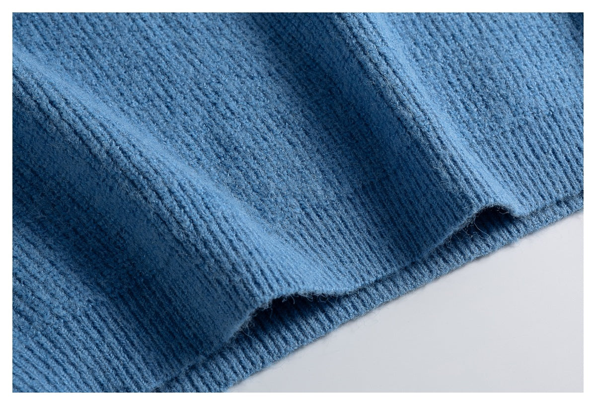 Close-up of the blue sweater’s ribbed hem with a folded edge.