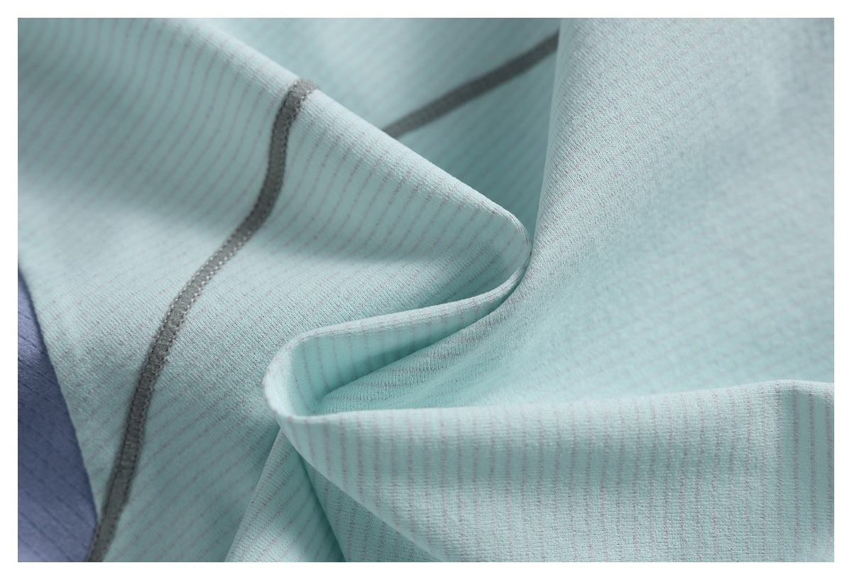Close-up of pale aqua fabric folds showing fine stripes and gray overlock stitching.
