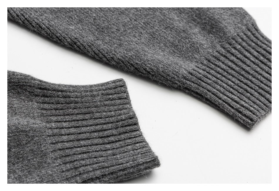 Close-up of a gray knit sleeve and ribbed cuff laid flat.