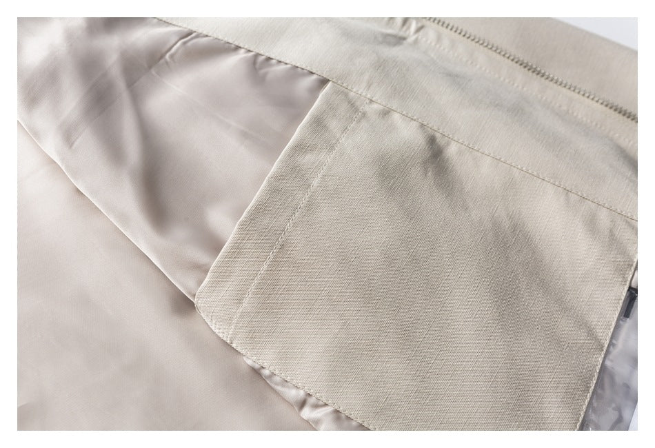 Close-up of a beige garment showing a stitched fabric panel, smooth lining, and a zipper edge.