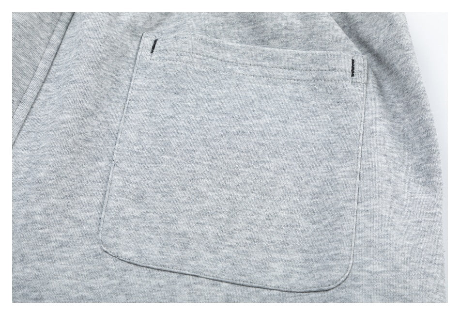 Close-up of a large patch pocket on light gray heathered shorts.