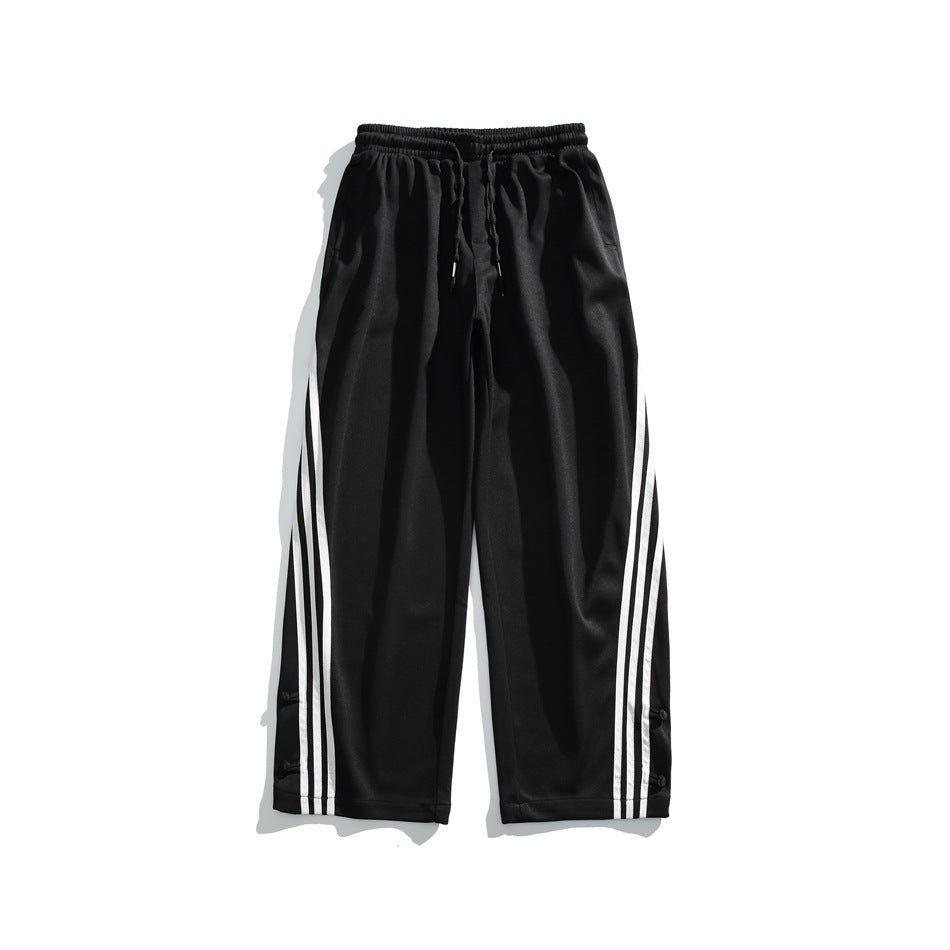 Black wide-leg pants with elastic drawstring waist and white three-stripe side detail, flat lay front view