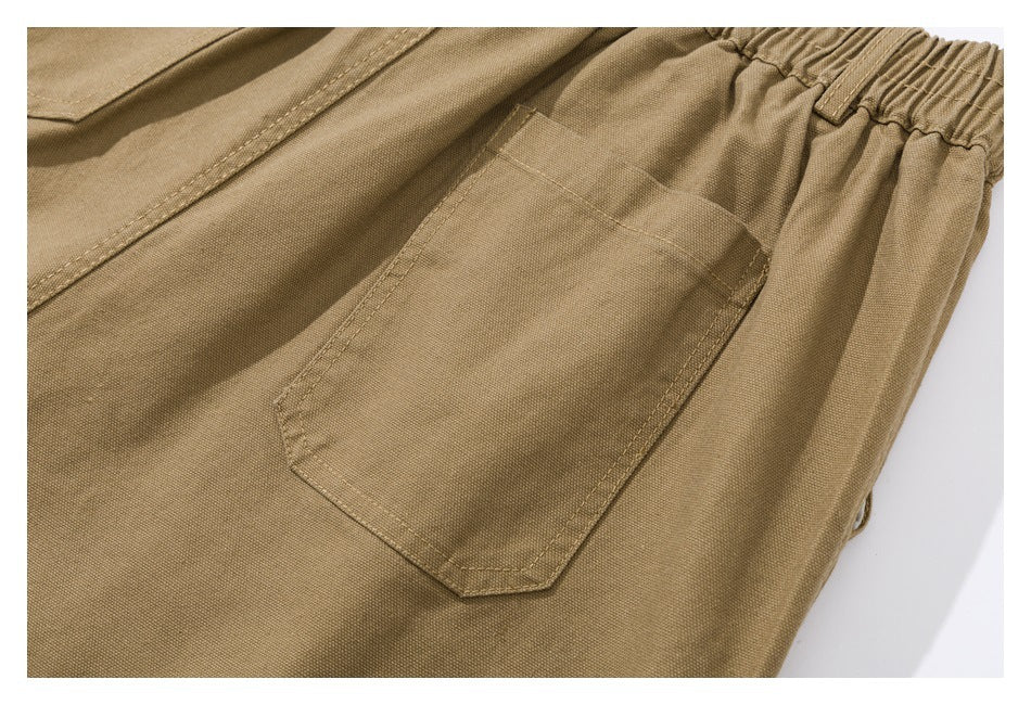 Close-up of tan shorts showing a rear patch pocket and gathered elastic waistband.