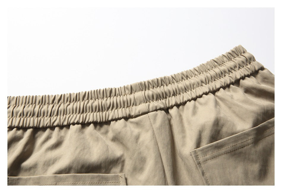 Partial back view of khaki shorts with an elastic waistband and two rear pockets.