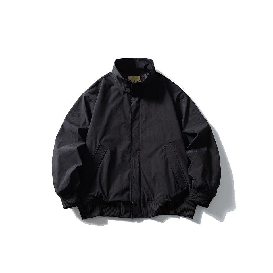 Black stand-collar jacket flat lay front view with concealed placket, angled pockets and ribbed cuffs and hem