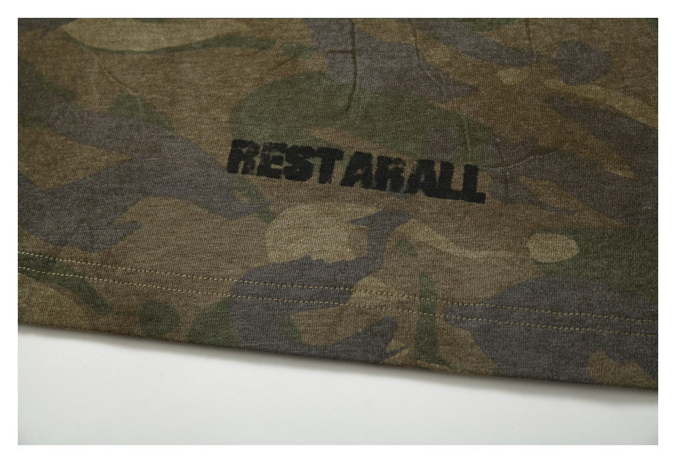 Close-up of camouflage fabric with the word “RESTART” printed above a stitched hem.