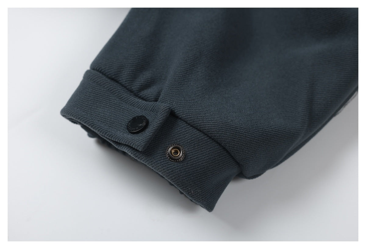 Close-up of a dark charcoal cuff with a black snap button and metal snap fastener.