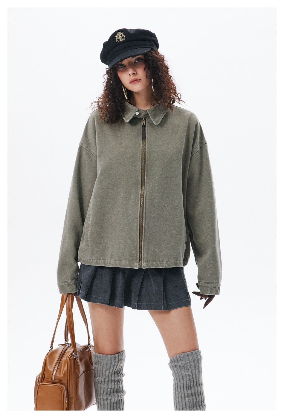 Front view of a model wearing an oversized olive-gray collared zip jacket with a dark skirt.