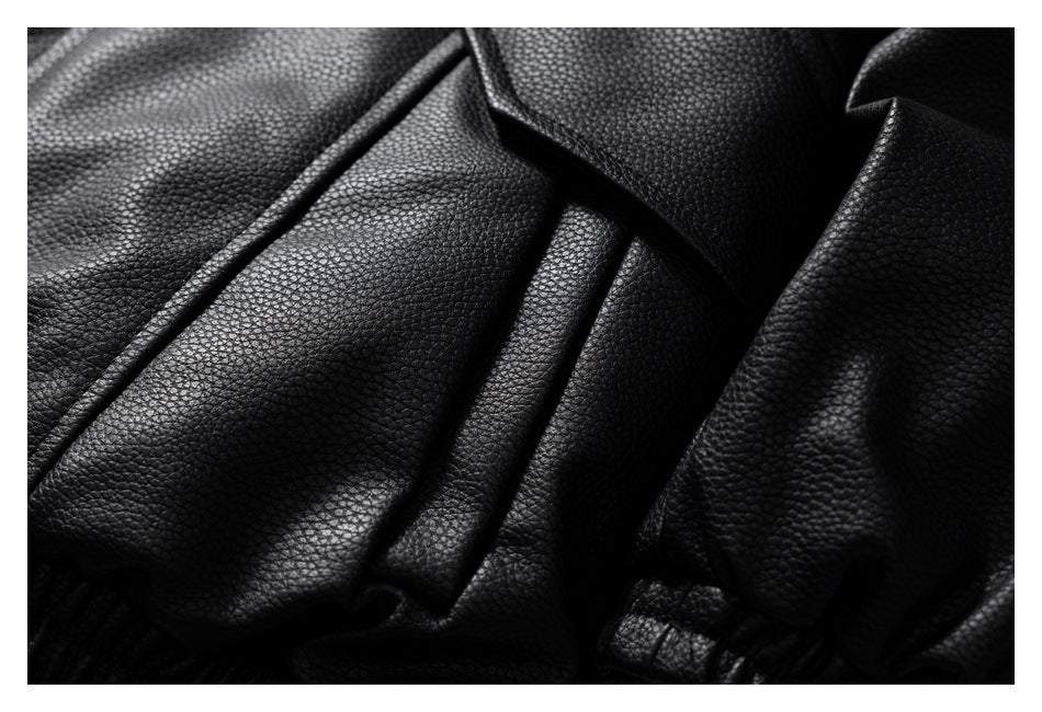 Close-up of a black jacket's flap pocket, stitched panels and gathered sleeve cuff.