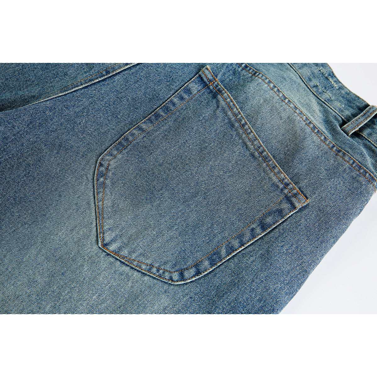 Close-up of a back patch pocket on faded blue denim shorts with orange contrast stitching.