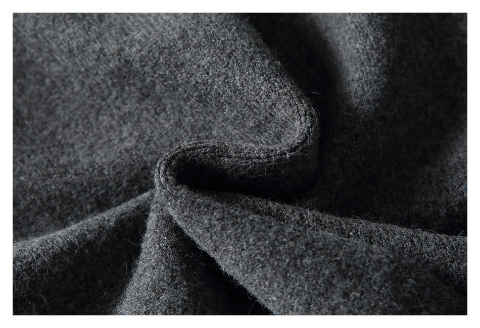 Close-up of a folded edge of dark gray fuzzy knit fabric.