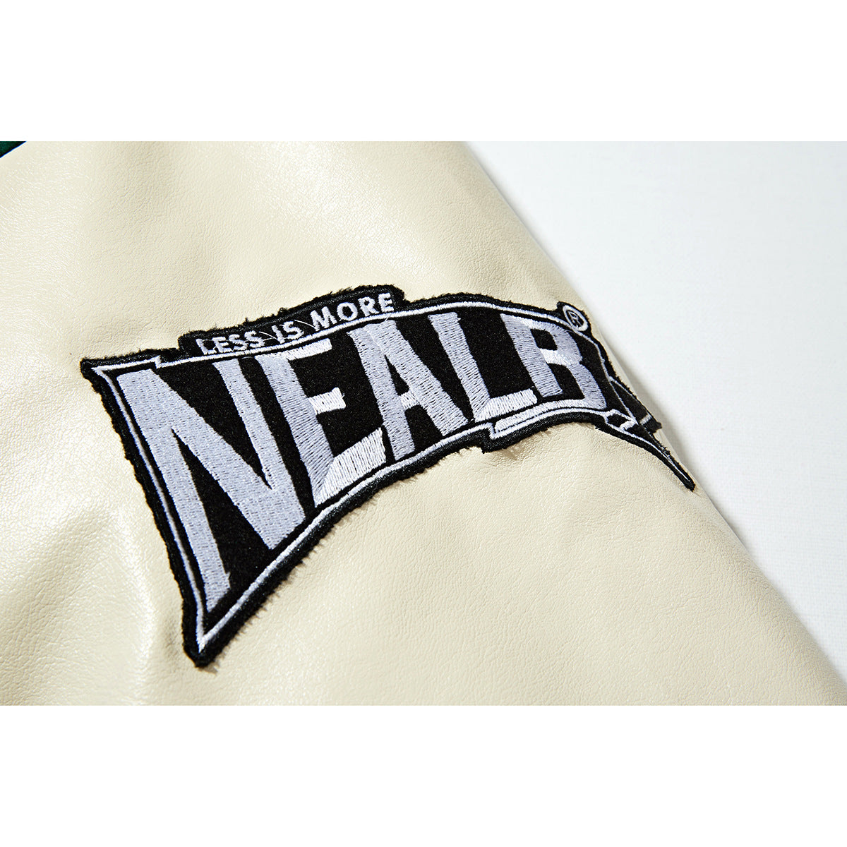 Close-up of a black-and-white embroidered patch on an ivory jacket sleeve.