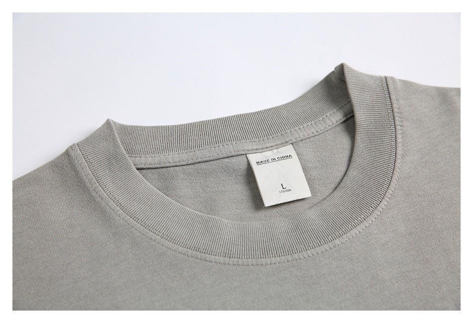 Close-up of a gray T-shirt’s ribbed crew neck and attached size label.