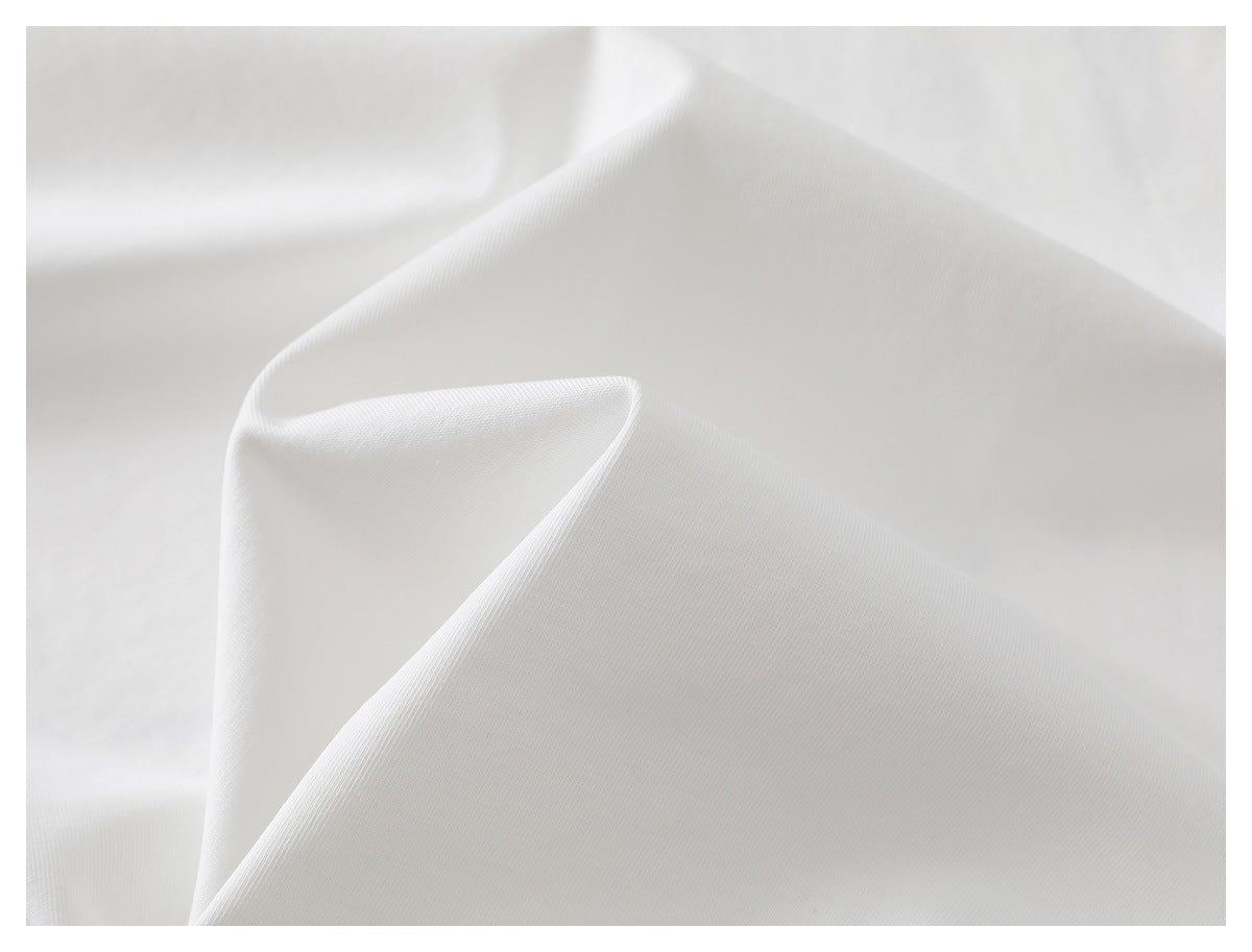 Close-up of white T-shirt fabric draped to show its smooth surface and folds.
