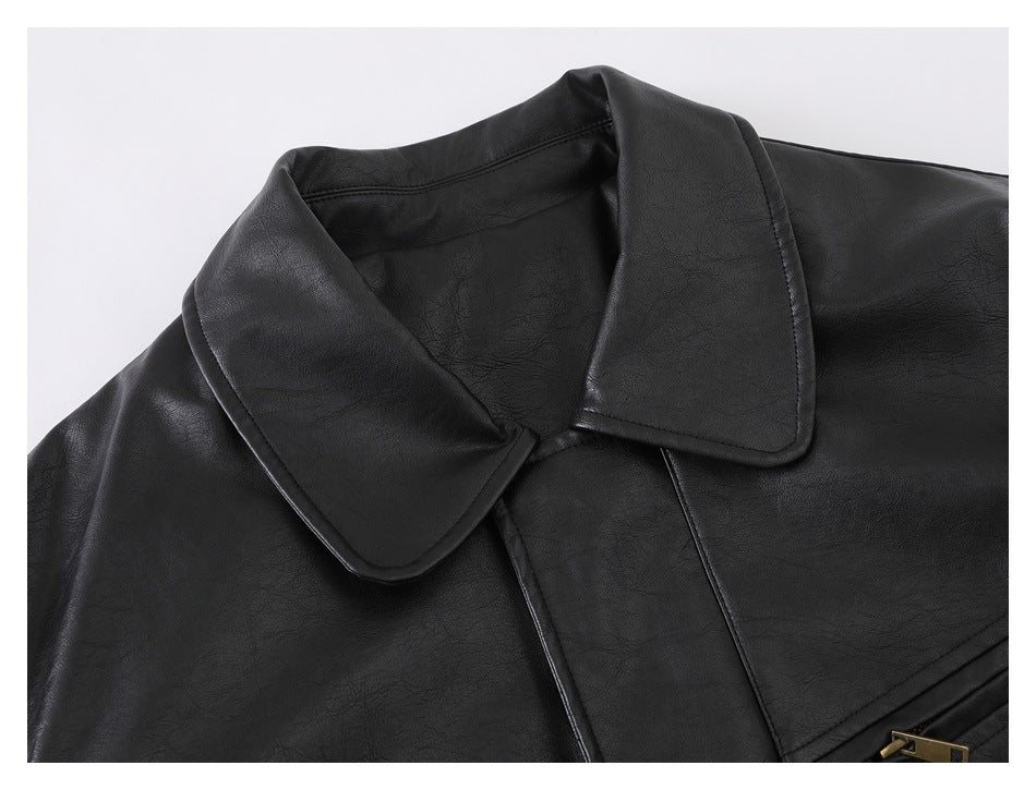 Close-up of a black jacket's broad collar and upper front against a pale background.