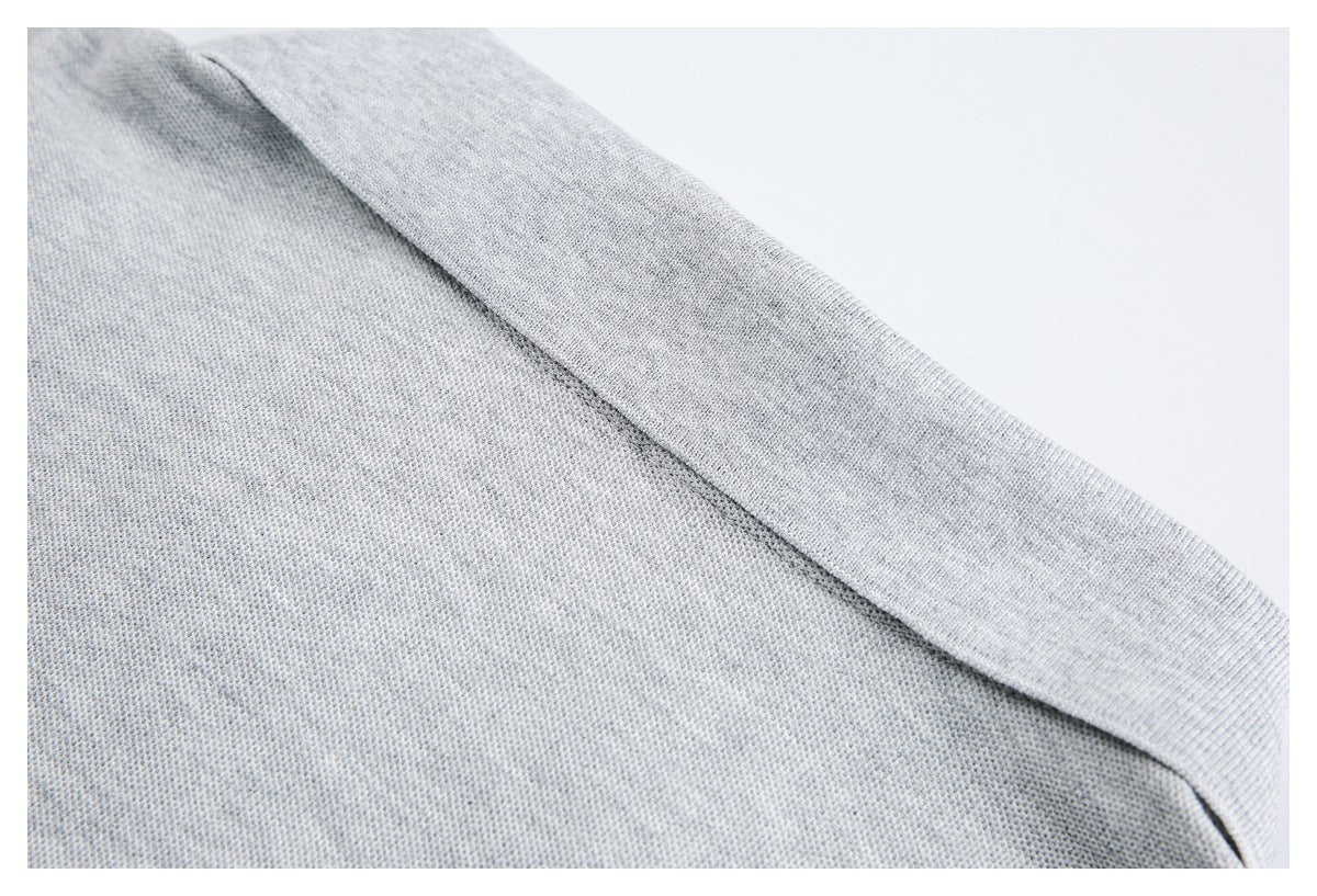 Close-up of a light gray ribbed knit cuff attached to textured fabric.