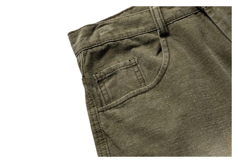Close-up of an olive trouser front pocket and small coin pocket with visible stitching.