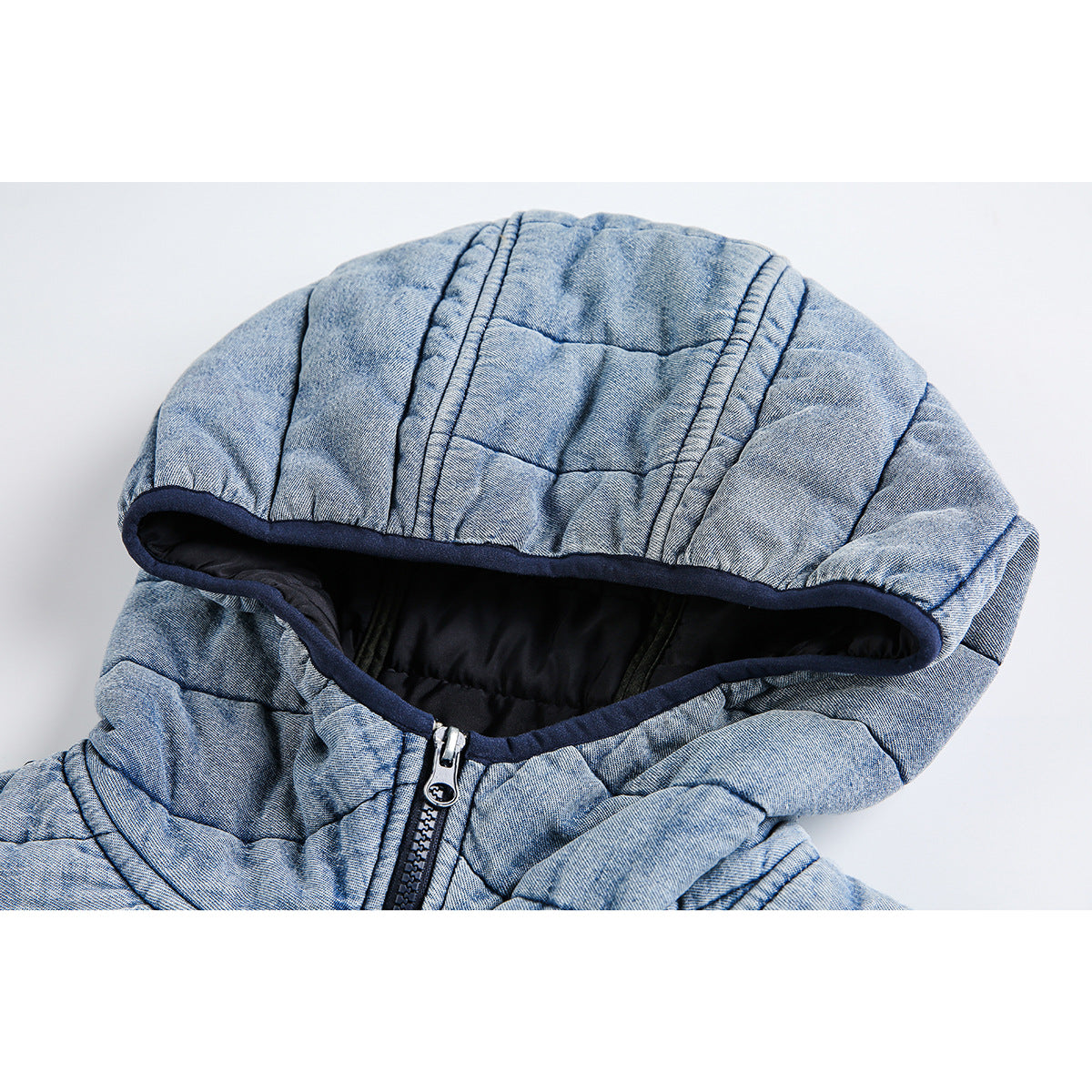 Close-up of a light blue quilted jacket hood with dark lining and navy edging.