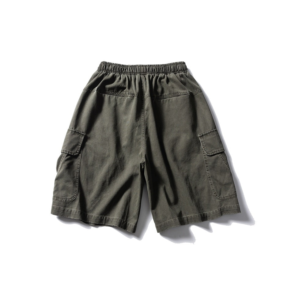 Back view of green cargo shorts showing elastic waistband, yoke seam and side flap pockets