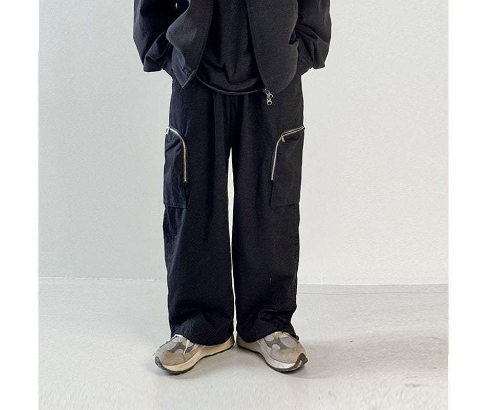 Person wearing black wide-leg cargo pants with zippered side pockets, shown from the waist down with sneakers