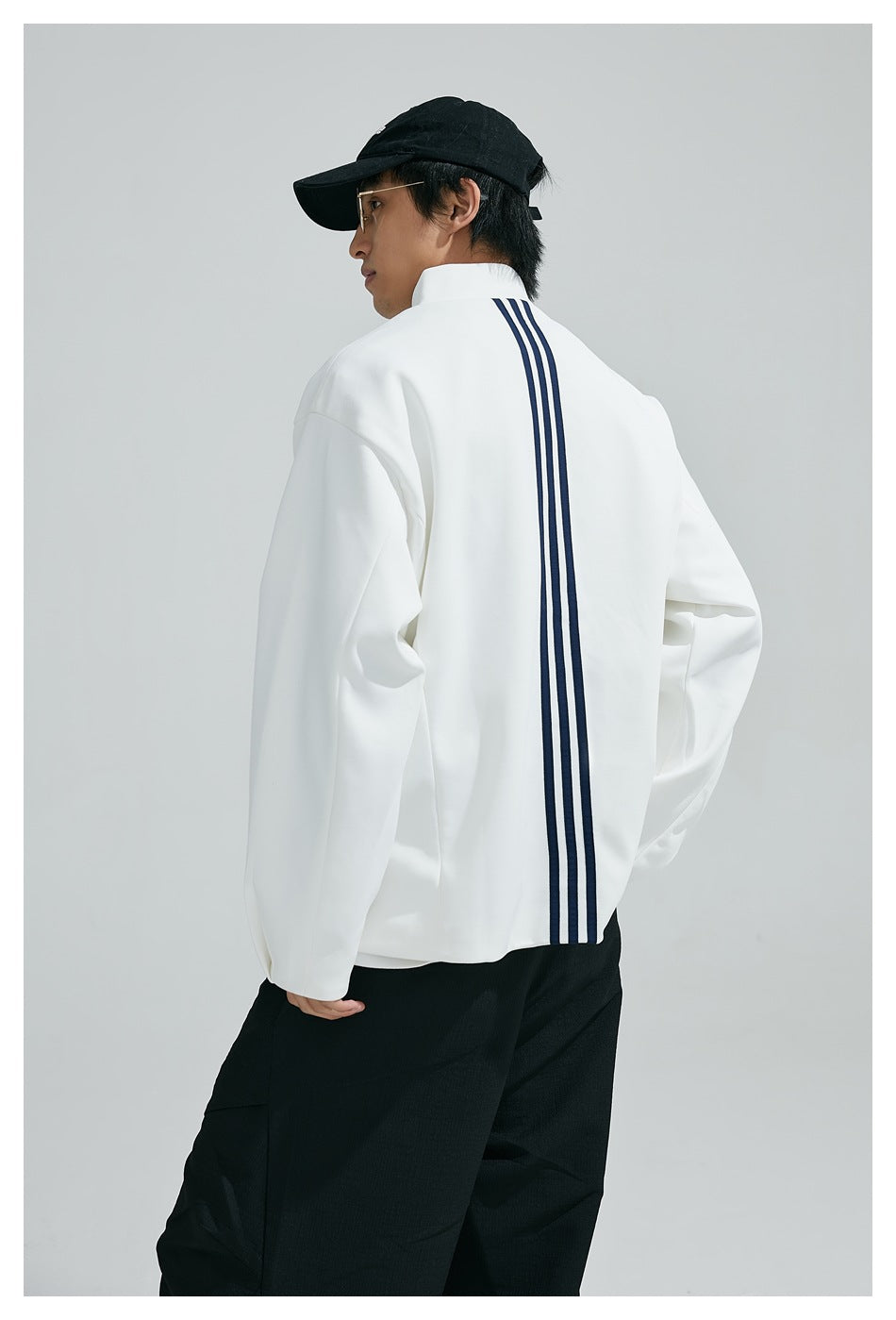 Back view of model in the white jacket showing three vertical navy stripes down the center back
