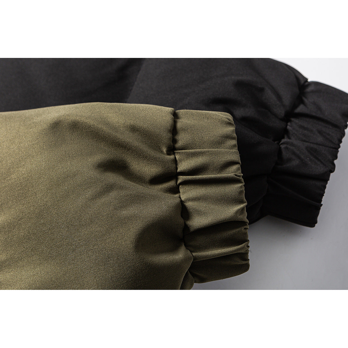 Close-up of gathered jacket cuffs in olive and black.