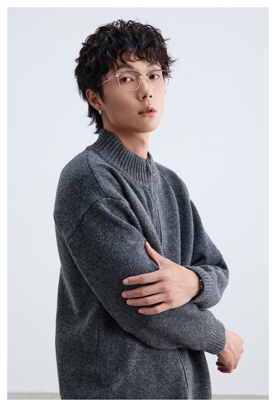 Man wearing a charcoal gray zip-front knit sweater with a ribbed stand collar and cuffs, shown at an angle.