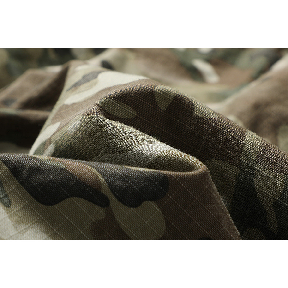 Macro view of folded olive, brown, and black camouflage fabric showing its woven texture.