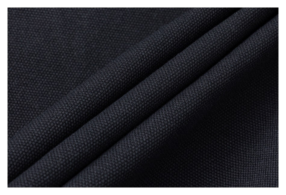 Macro view of the black jacket's textured fabric folded into overlapping layers.