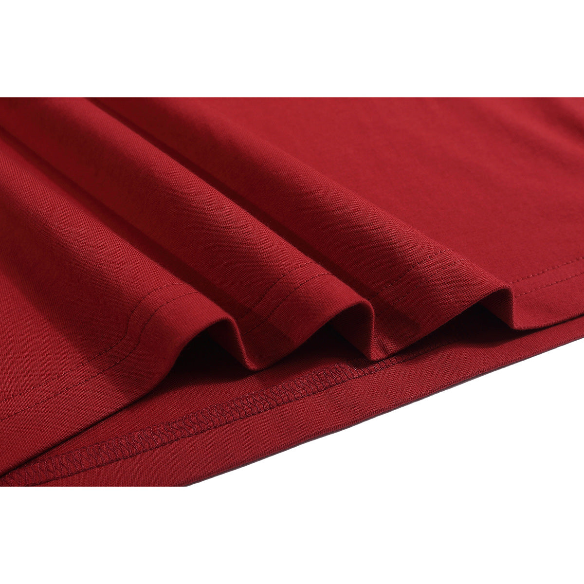 Close-up of the red T-shirt’s folded hem, showing the stitching and fabric texture.