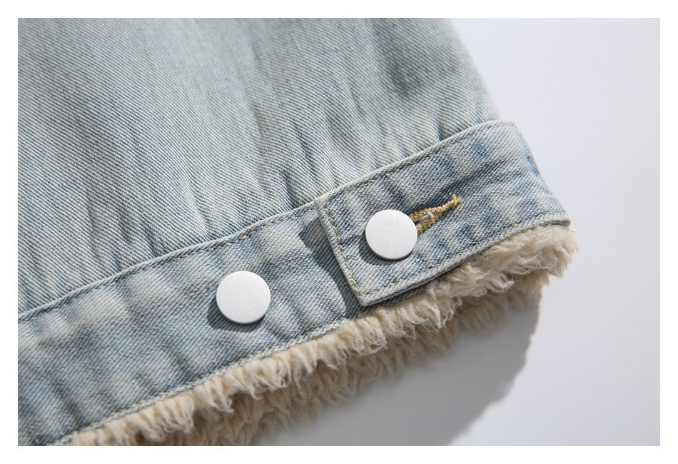 Close-up of a denim jacket cuff with two silver snaps and cream fuzzy lining at the edge.