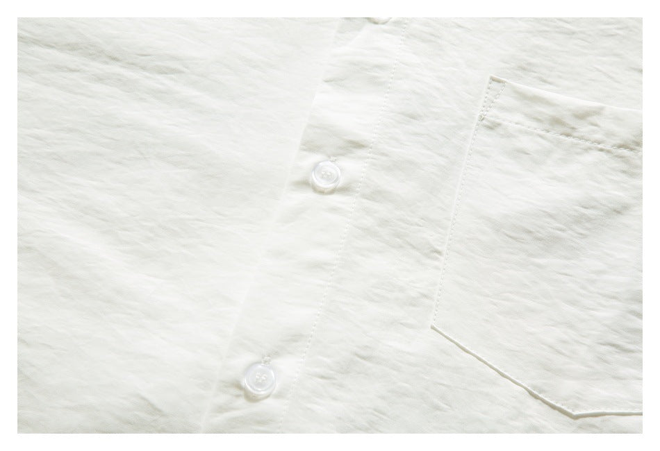 Close-up of an ivory shirt front showing the button placket and edge of the chest pocket.
