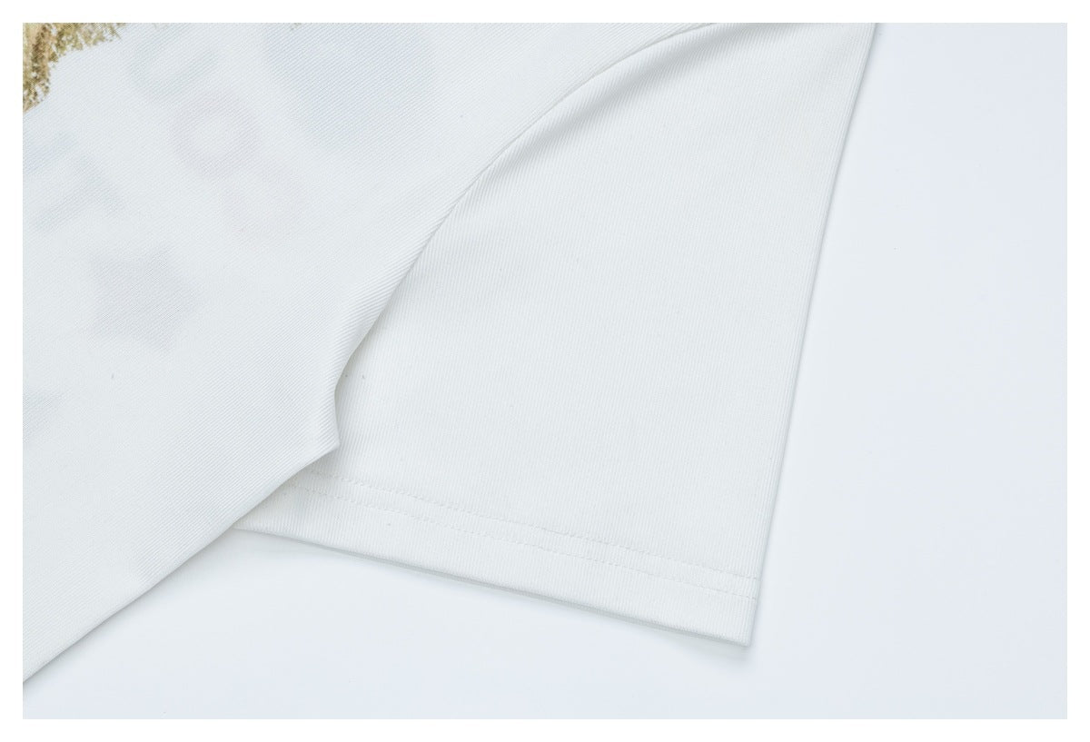 Close-up of a white T-shirt sleeve and stitched hem, with part of the printed design at the edge.