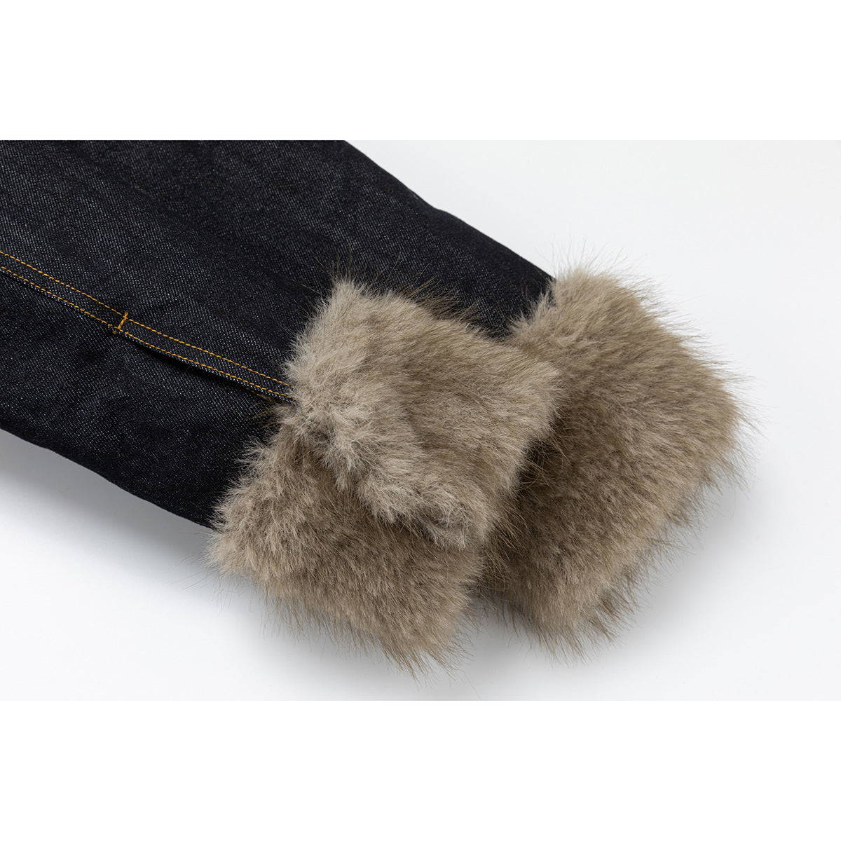 Close-up of a dark denim sleeve ending in a wide tan faux-fur cuff.